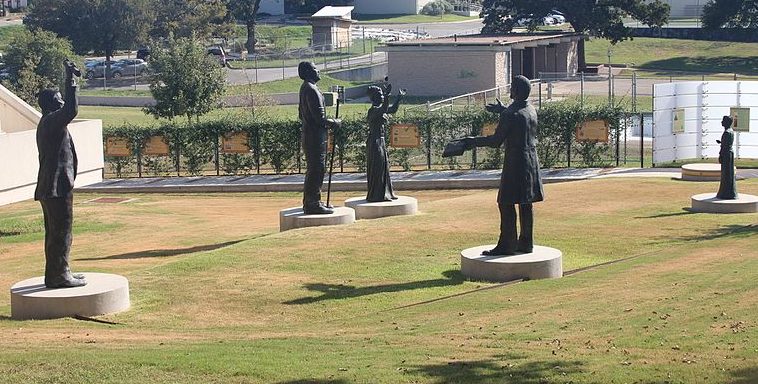 The Juneteenth Memorial Sculpture Monument at The George Washington Carver Museum in Austin, Texas, opened to the public June 27, 2015. It is made up of five bronze figures that represent the story of Juneteeth and a paved timeline of the Black Presence in the Americas—from the Middle Passage to the Emancipation Proclamation that leads to the Bell of Freedom.