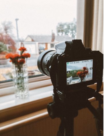 A digital camera taking a photo of flowers.