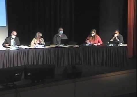 Board members sit and discuss