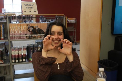 Student raising hands in claws in library