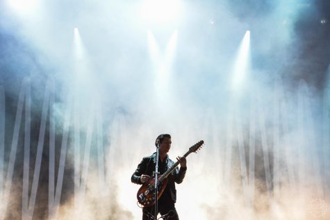 Man in front of smoke with guitar and microphone