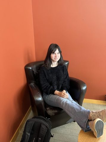 Student sitting in chair with red background