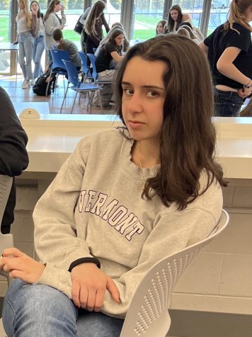 Student sitting at counter in cafeteria with a scornful glance