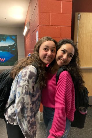 Two girls smiling together in the hallway