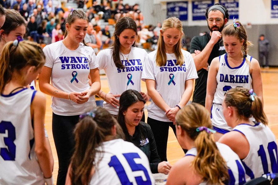 Darien Girls Basketball head coach Ms. Alyssa Valente talking to her team during a timeout in a game against New Canaan.