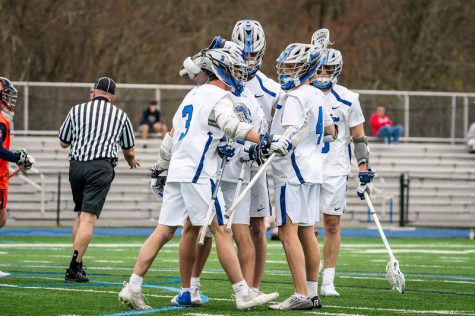 Darien Boys Lacrosse Team celebrating a goal in a 2022 meeting with the Manhasset Indians.