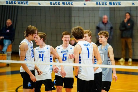 The Darien Boys Volleyball team huddling up after a point victory in a 2022 contest inside the DHS Main Gym