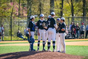 The Darien baseball team huddled around the pitchers mound during a 2022 game against New Canaan.