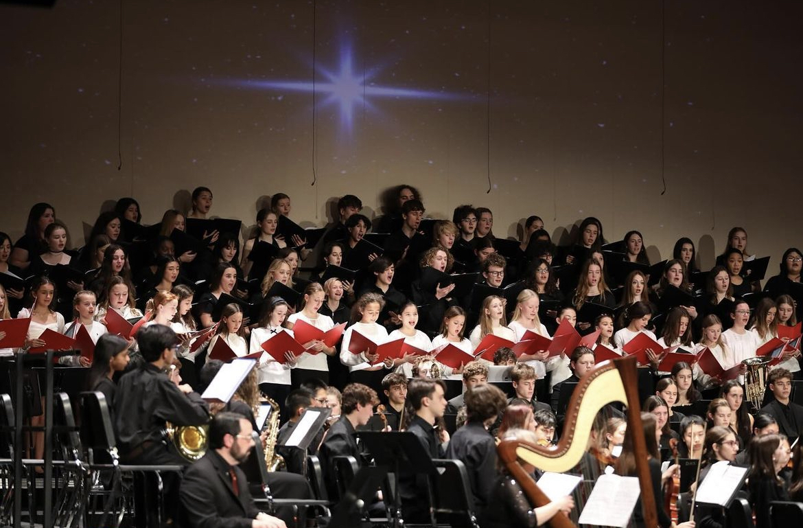 The DHS Tudor Singers, DHS Concert Choir, DHS Band, DHS Orchestra, and MMS Viva Voce choir performing together in the Holiday Spectacular Concert on December 19th. Photo Credit: Instagram (@dhs.bluewaveband)